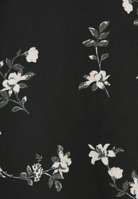 Tissu noir avec un motif répétitif de petites fleurs blanches et roses pâles avec des feuilles vertes et de fines tiges.