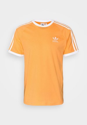 Orange Adidas t-shirt med korte ærmer og hvide kanter på ærmer og krave, med hvid Adidas-logo og tre striber på skuldrene.
