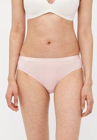 Lichtroze katoenen slip met een gladde afwerking, middenhoog tailleband en geen zichtbare patronen of hardware. Eenvoudig, functioneel ontwerp.
