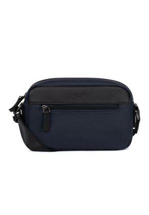 Prostokątna torba na ramię w kolorze granatowym z czarną skórzaną lamówką, przednią kieszenią na zamek i regulowanym czarnym paskiem na białym tle.