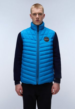 Blauwe gewatteerde vest met hoge kraag, ritssluiting en marineblauwe mouwen; heeft een ronde logo patch op de borst en een gestructureerde bovenstof.
