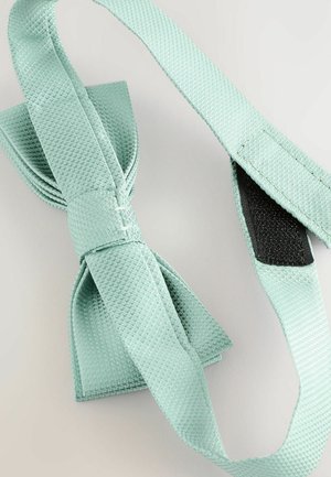 Mintgrøn butterfly lavet af tekstureret stof, med et ensfarvet butterflydesign og en velcrolukning for sikker fastgørelse.