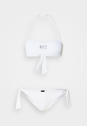 Completo bikini bianco con top a fascia caratterizzato da un laccio frontale e dettaglio logo, abbinato a slip con laccetti laterali. Texture liscia, design minimalista.