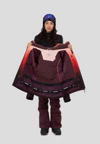 Skijack in bordeaux en roze stof, met een ritssluiting aan de voorkant, binnenzakken en een uniek verloopontwerp. Gevoerd voor extra warmte.