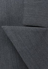 Tmavě šedá látka s texturovanou vazbou, hladkým povrchem a detailním přehnutím rohu. Materiál vypadá odolně a robustně.