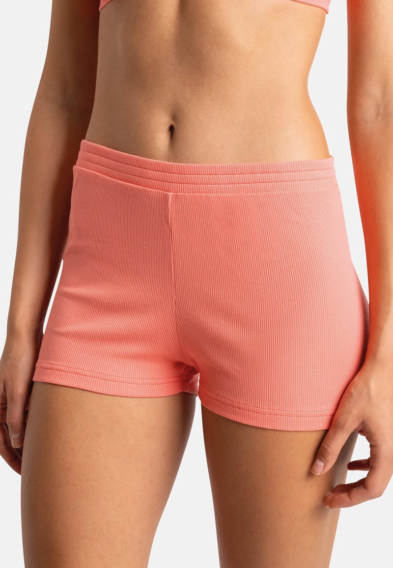 Shorts en tissu côtelé et extensible d'une couleur corail vive. Présentent une coupe ajustée avec une taille élastique douce et une longueur mi-cuisse.
