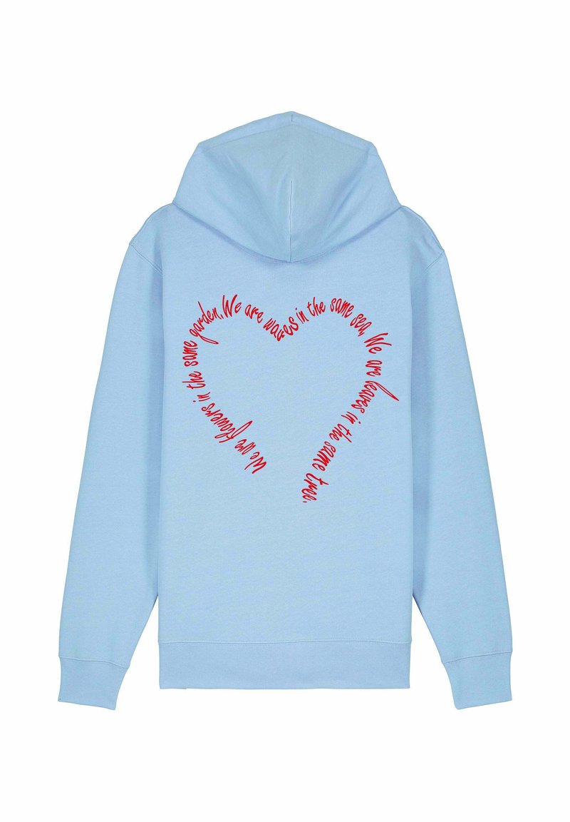 Világoskék kapucnis pulóver ribbelt mandzsettával. A hátsó részen piros színű szív alakú felirat található, amely egy idézetet tartalmaz dőlt betűs betűtípussal.