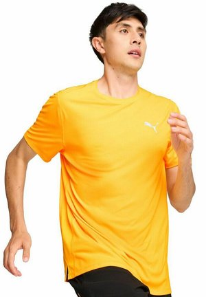 Camiseta atlética de manga corta en color naranja brillante, hecha de una tela ligera. Presenta un escote redondo y un pequeño logo blanco en el pecho.