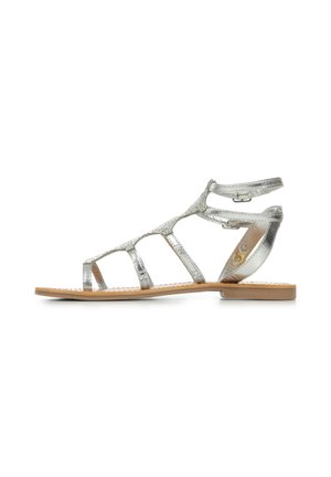 Zilverkleurige metallic sandalen met bandjes, platte zool, geprofileerde banden, verstelbare enkelgesp en een glad bruine voetbed.