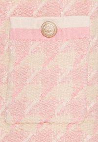 Pletený svetr v měkké krémové a růžové barvě s texturovaným herringbonovým vzorem. Obsahuje růžovou pruhovanou kapsu s ozdobným zlatým knoflíkem.