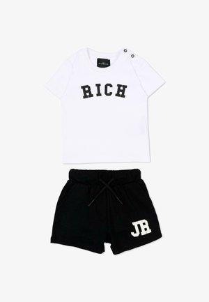Chemise blanche à manches courtes avec le texte "RICH" et short noir avec cordon de serrage et texte "JR" sur la jambe gauche, posés à plat sur fond blanc.