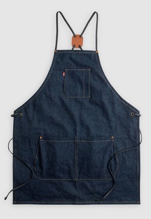 Denim apron with dark blue fabric, adjustable straps, leather accent at top, front pocket, and two bottom pockets with visible stitching.