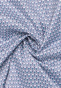 Katoenen stof met een lichtblauw en marineblauw patroon van pauwenveren, gladde textuur en een draaivormige indeling, die fijne ontwerpdetails laat zien.