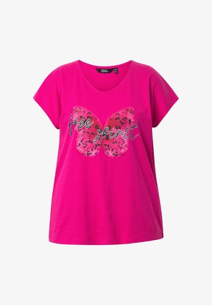 Różowa bawełniana koszulka o luźnym kroju, z grafiką motyla w różowym i czarnym kolorze oraz napisem "wolny duch" na białym tle. Wycięcie w serek.