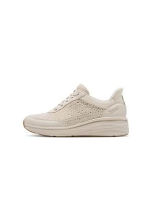 Sneaker beige con tessuto lavorato a maglia, chiusura frontale con lacci, suola imbottita e marchio discreto sul tallone, vista laterale.