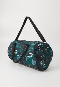 Dufflebag met een ronde vorm, gemaakt van stof met een groen en zwart bloemenpatroon. Inclusief een rits en twee zwarte schouderriemen.