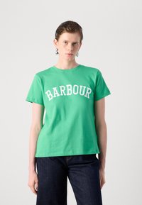 Zelené bavlněné tričko s kulatým výstřihem a krátkými rukávy. Na hrudi je vytištěno "BARBOUR" bílými blokovými písmeny.