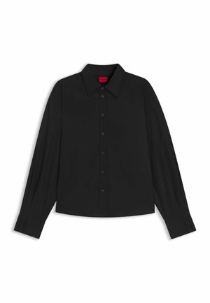 Camicia nera a maniche lunghe con bottoni, polsi larghi e colletto a punta su uno sfondo bianco.