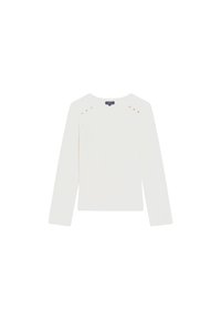 Camiseta blanca de manga larga con un cuello redondeado, que presenta tachuelas doradas en los hombros y una tela suave y ligera.