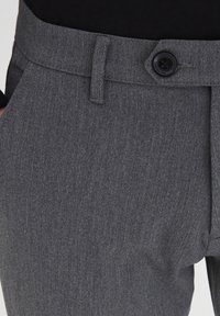 Pantalones a medida gris con una textura sutil, que cuentan con una cintura estándar, cierre de botones y bolsillos delanteros.