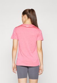 T-shirt atlético rosa claro feito de um tecido suave, com mangas curtas e decote redondo, apresentando um logótipo discreto nas costas.