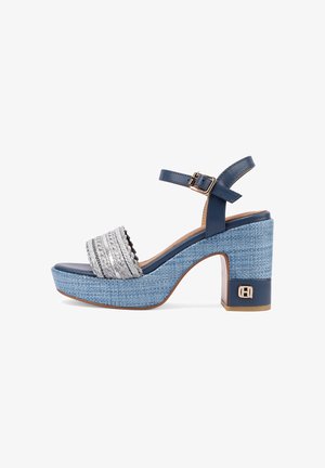 Sandale à plateforme bleue avec talon texturé tressé, bride argentée tressée, boucle à la cheville et détail de logo doré sur le talon large.