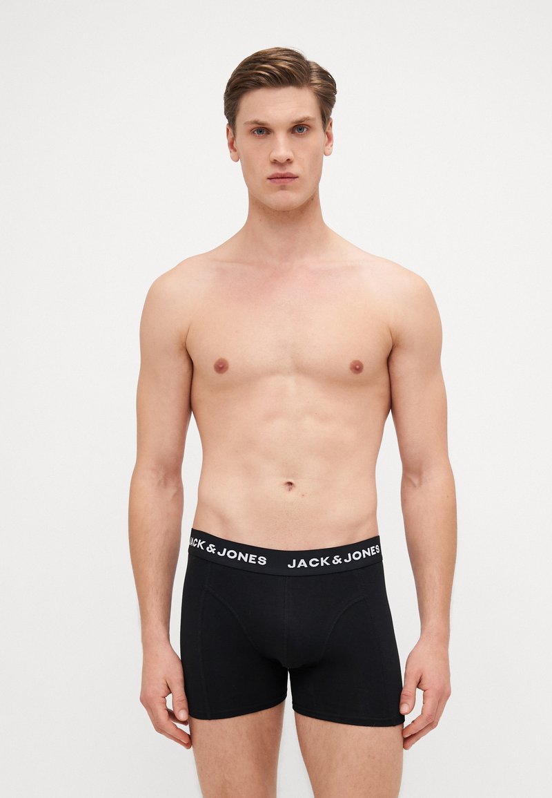 Schwarze Boxer-Shorts mit einem weißen Gummibund, auf dem "JACK & JONES" steht. Hergestellt aus glattem, dehnbarem Stoff, im taillierten Design.