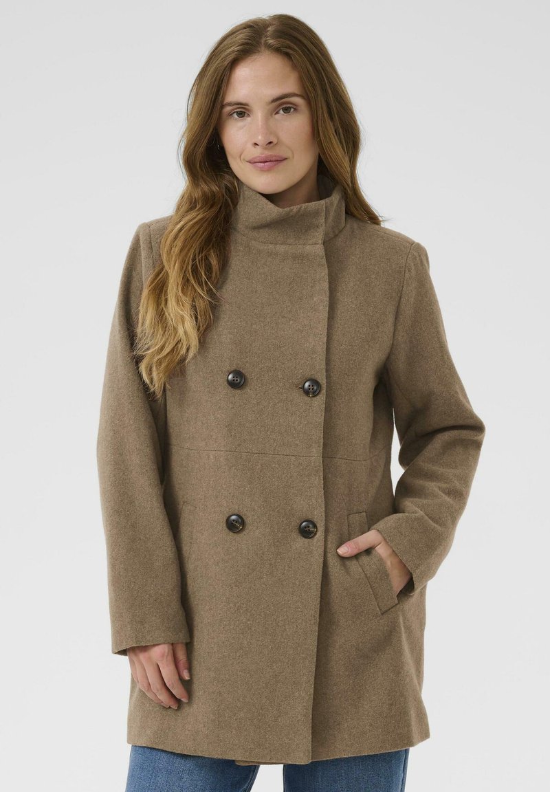 Braune, doppelt-knopflose Jacke mit hohem Kragen, Knopfakzenten und Seitentaschen; aus einem strukturierten, warmen Stoff gefertigt.