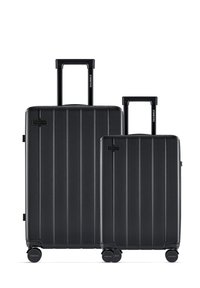 Black hard-shell luggage set with vertical ridges, featuring two sizes. Both have retractable handles and smooth-rolling wheels.