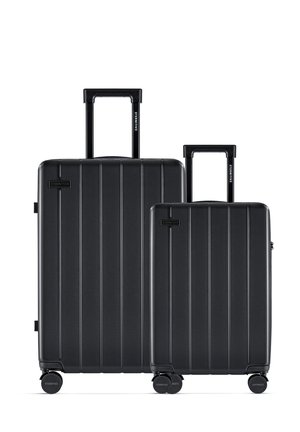 Black hard-shell luggage set with vertical ridges, featuring two sizes. Both have retractable handles and smooth-rolling wheels.