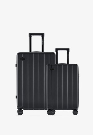 Schwarz hartschaliges Gepäckset mit vertikalen Rillen, bestehend aus zwei Größen. Beide haben ausziehbare Griffe und leichtgängige Räder.