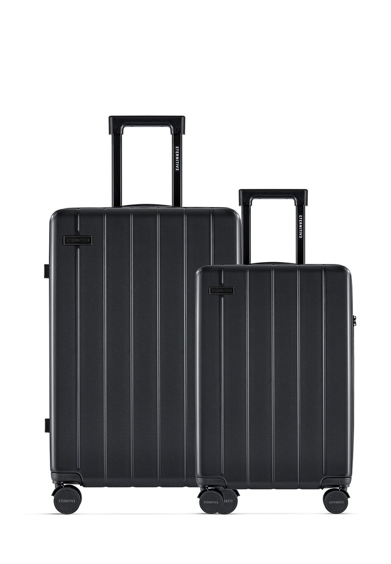 Black hard-shell luggage set with vertical ridges, featuring two sizes. Both have retractable handles and smooth-rolling wheels.