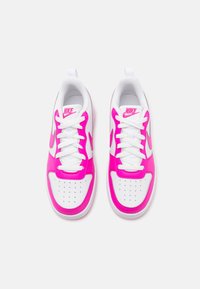 Nike-sneakers med vit bas, rosa detaljer och perforerat tånät. Har vita snören och en texturerad yta på ovandelen.