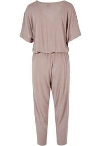 Udobno prilegan jumpsuit v svetle bež barvi, z kratkimi rokavi, širokimi hlačami in elastičnim pasom, izdelan iz mehkega, gladkega materiala.