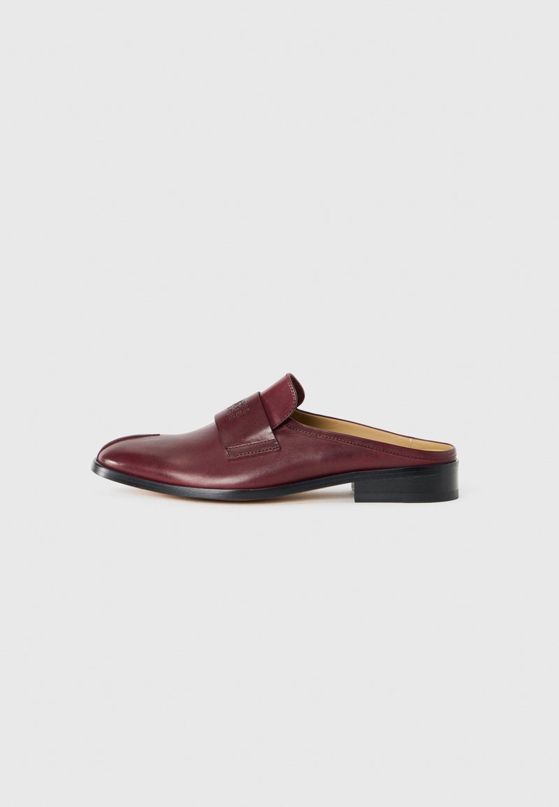Burgundy läder slip-on sko med låg, rund tå, platt häl och ett texturerat band över framtill. Slät yta med subtila sömmar.