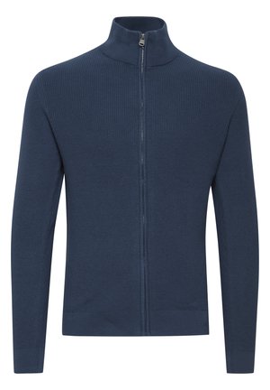 Tumesinine zip-up sviiter kõrge kaelusega, sooniktekstuuriga, pikkade varrukatega ja kitseneva äärega. Valmistatud kootud kangast sooja hoidmiseks.