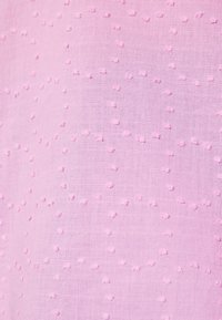 Light pink fabric featuring a textured pattern of raised dots, creating a delicate and dimensional look. Smooth and lightweight texture.