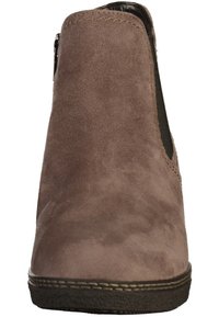 Bottine en daim marron avec panneaux élastiques latéraux et doublure intérieure noire. Détails cousus le long de la semelle. Design à bout arrondi.