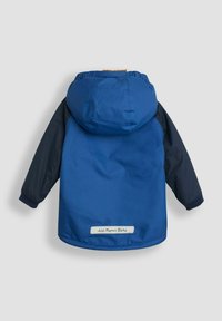 Blå jakke med marinefarvede ærmer, hætte og elastiske manchetter. Har et mærke med "JoJo Maman Bébé" på kanten. Glat, vandtæt materiale.