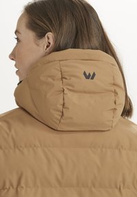 Brun polstret jakke med høj krave og et diskret logo bagpå. Materialet er glat med en mat overflade.