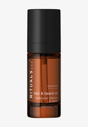 Flacon ambré d'huile pour cheveux et barbe Rituals homme avec bouchon noir, contenant du cèdre et de la vitamine E, présenté sur fond uni.