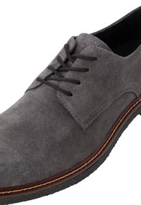 Pantof gri din suede cu un design clasic cu șireturi, având cusături contrastante și o talpă din piele maro cu o suprafață texturată.