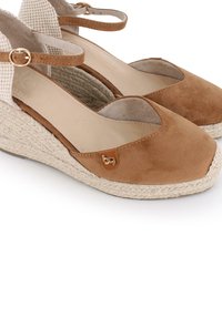 Zapatos de cuña de ante marrón con diseño de punta abierta, suela de yute trenzado y correa ajustable en el tobillo con detalle de hebilla en tono dorado.