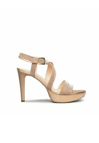 Beige high-heeled sandals with crisscross straps, textured fabric, an adjustable ankle buckle, and a platform sole.