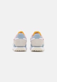 Puma sneakers featuring a light pink, blue, and gray textile upper with a textured suede heel and yellow accents, lightweight rubber sole.