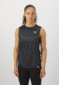 Svart atletisk tank topp med et teksturert mønster og reflekterende detaljer, med rund hals og uten ermer.