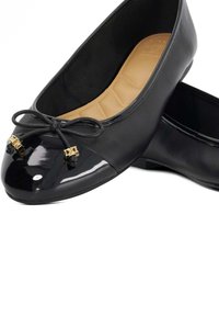 Zwarte ballerina's met een glanzend zwart lakleren neus, decoratieve strik en gouden hardware-accenten. Soepel leren bovenkant met een zachte beige binnenzool.