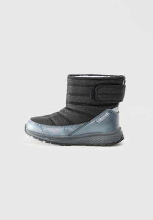 Schwarze und silberne Knöchelstiefel aus gestepptem Stoff, mit Klettverschluss und strukturiertem Sohlen. Merkmale metallische Akzente und ein weiches Innenfutter.