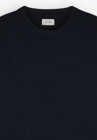 Camiseta de algodón azul marino con cuello redondo, que presenta una etiqueta que dice "SCALPERS", ajuste ceñido y sin patrones ni acentos visibles.