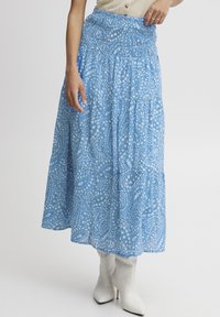 Fustă maxi cu imprimeu albastru, cu talie elastică, dintr-un material fluid, având un design complicat cu motive paisley albe și o siluetă în straturi.
